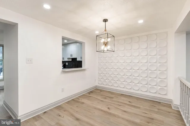 an empty room with wooden floor and ceiling fan
