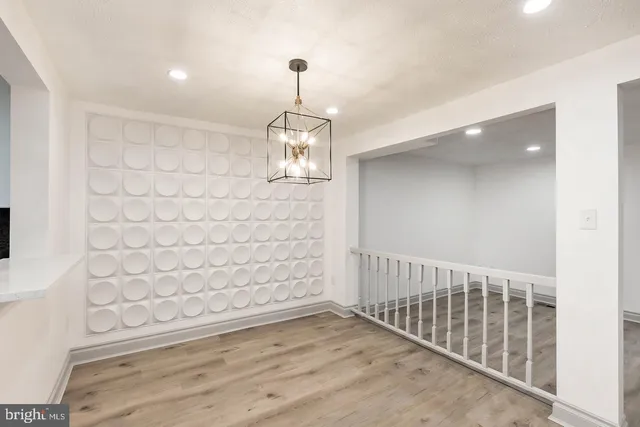 a view of a hallway with wooden floor and chandelier