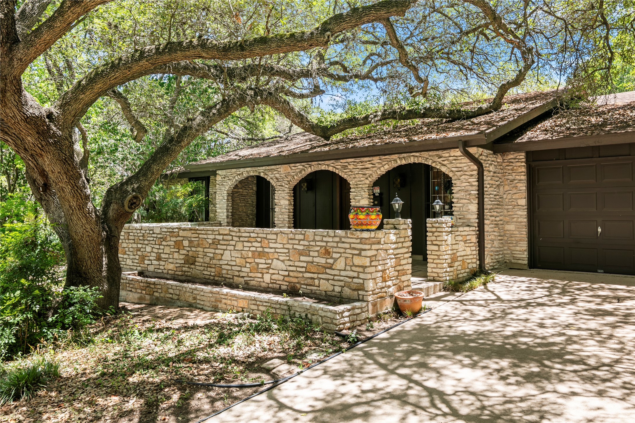 a front view of a house with large trees