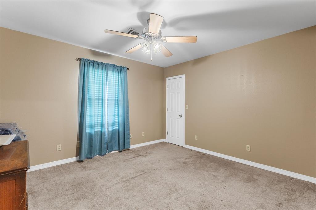 13315 Highway 281 Scotland, TX 76379 - Photo 22 of 40 Bedroom 2 featuring neutral wall tones, carpet, a window with horizontal blinds, and a ceiling fan with integrated lighting