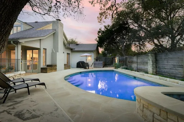 a view of swimming pool with chairs and table