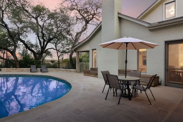 a view of a house with swimming pool and sitting area