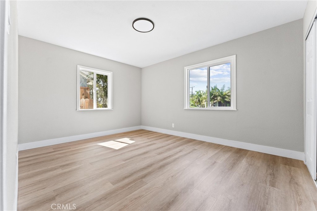 8039 4th Street Downey, CA 90241 - Photo 16 of 26 a view of an empty room with wooden floor and a window