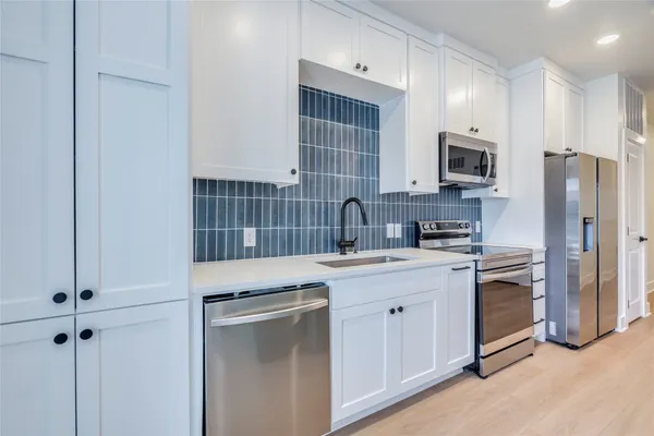 a kitchen with cabinets stainless steel appliances and a sink