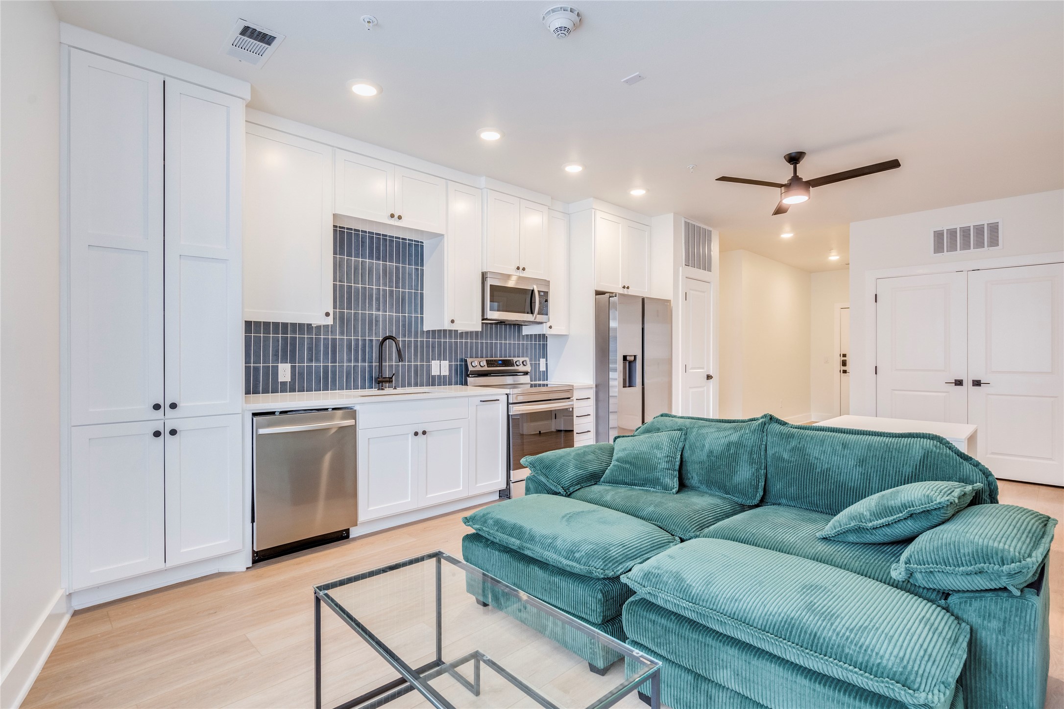 3000 Duval Street, Unit 207 Austin, TX 78705 - Photo 7 of 34 a living room with furniture a kitchen island a sink cabinets and a refrigerator