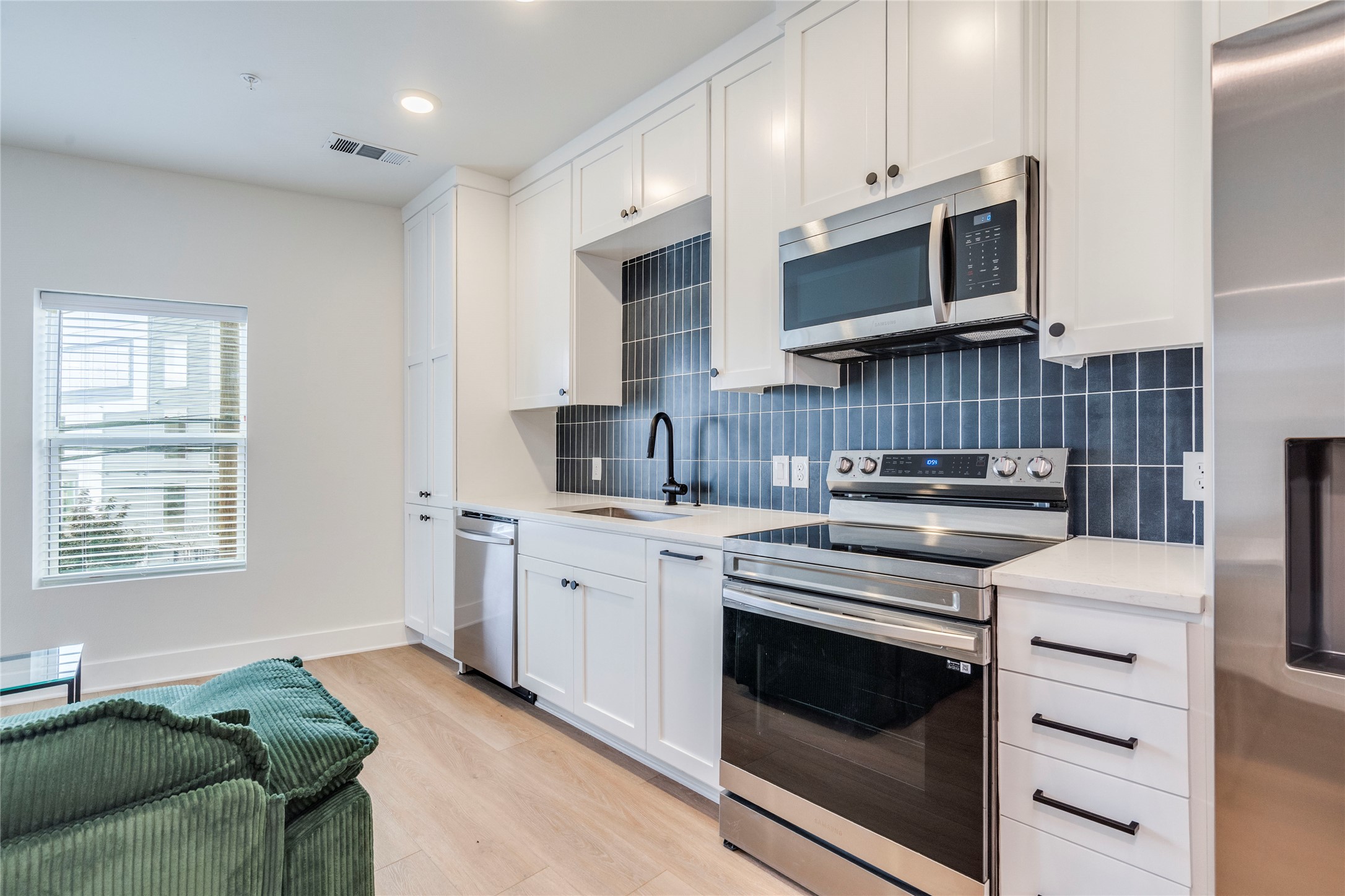 3000 Duval Street, Unit 207 Austin, TX 78705 - Photo 8 of 34 a kitchen with stainless steel appliances white cabinets and a stove top oven