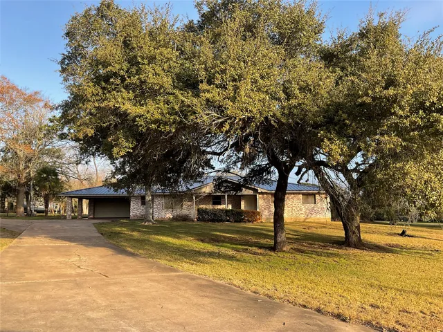 a view of a house with large trees
