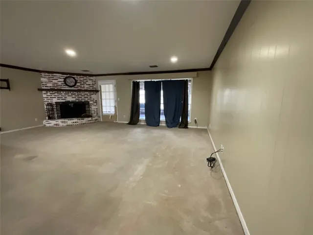 an empty room with fireplace and windows