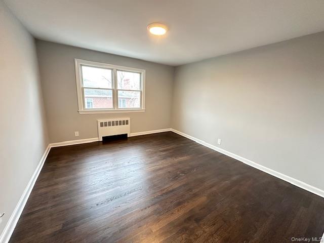 7 Linwood Road North, Unit 2 Port Washington, NY 11050 - Photo 8 of 13 Bedroom featuring dark wood-type flooring and radiator heating unit