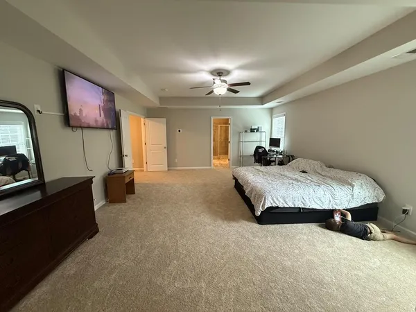 a spacious bedroom with a bed and a chandelier