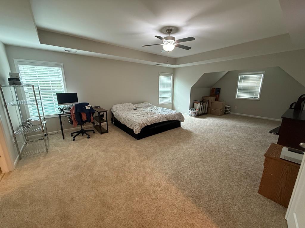 57 Hart Ridge Court Fortson, GA 31808 - Photo 26 of 38 a spacious bedroom with a bed and a chandelier