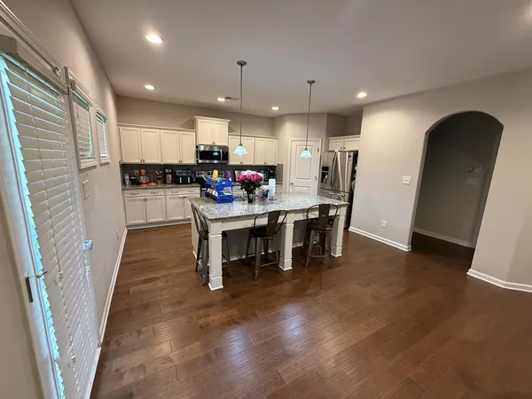 a kitchen with a dining table chairs and refrigerator