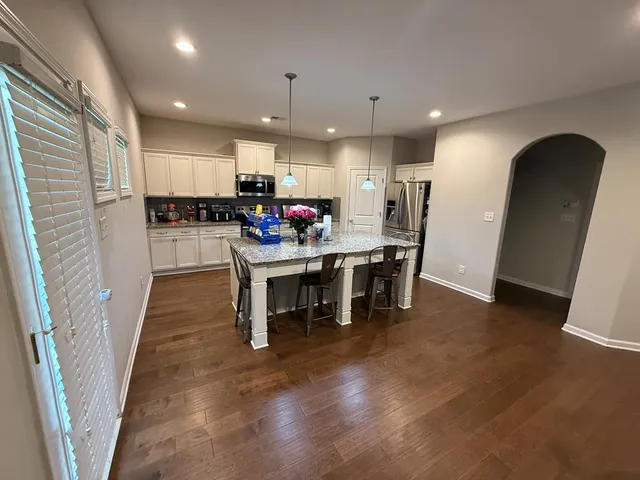 a kitchen with a dining table chairs and refrigerator