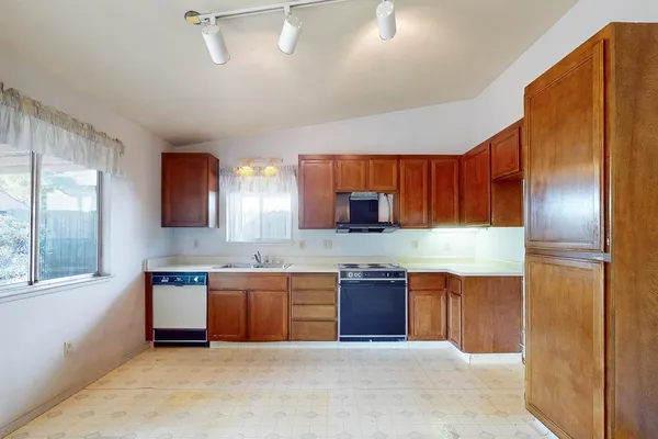 a kitchen with stainless steel appliances granite countertop a sink and a refrigerator