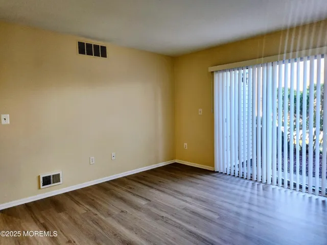 a view of a room with wooden floor and a window