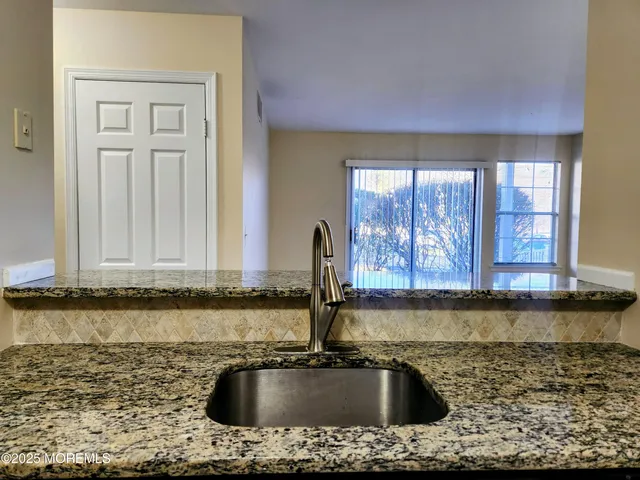 a kitchen with sink a window and cabinets