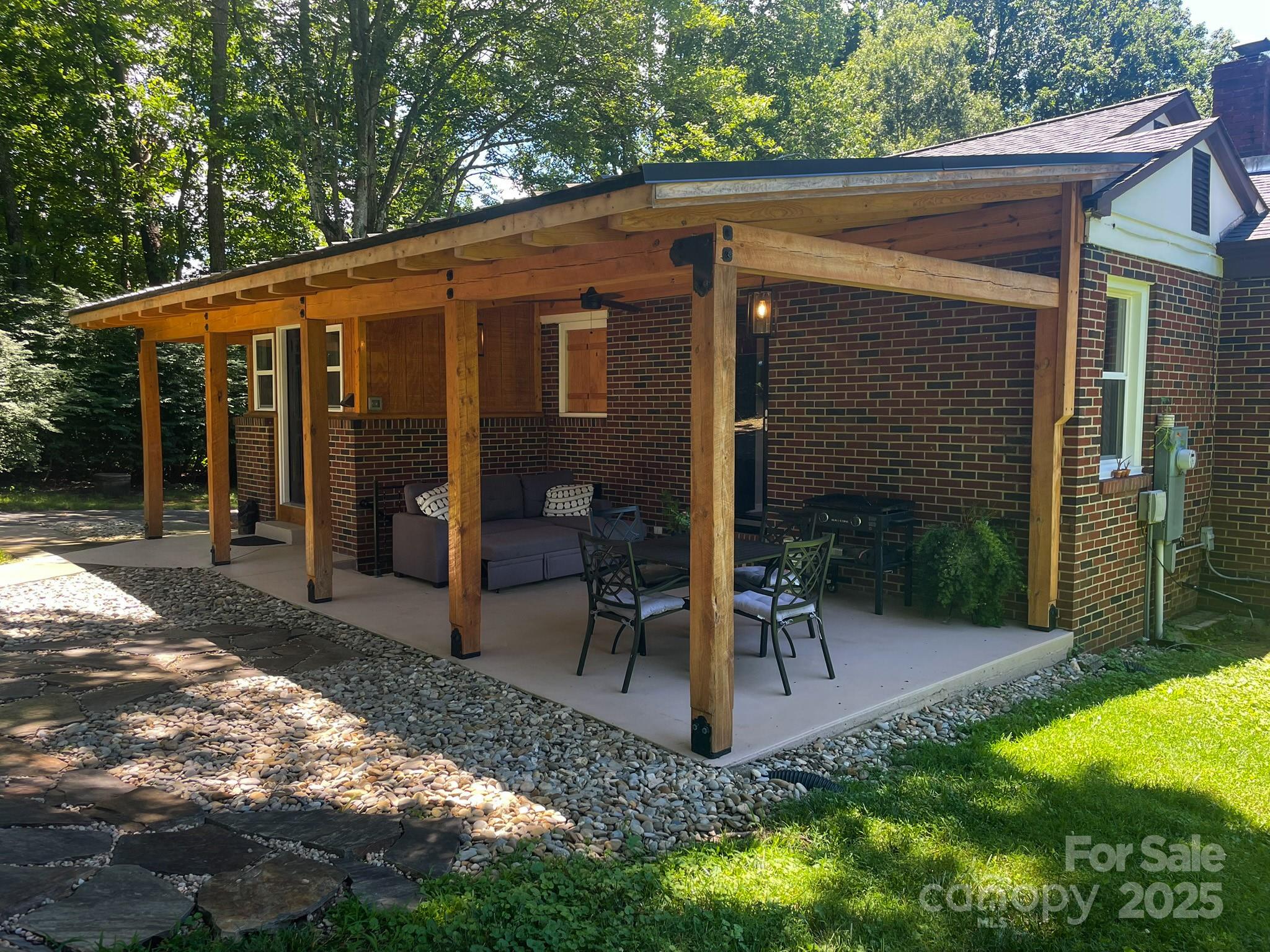 107 Byrd Street Morganton, NC 28655 - Photo 24 of 46 a view of a patio with table and chairs a barbeque with wooden fence and plants