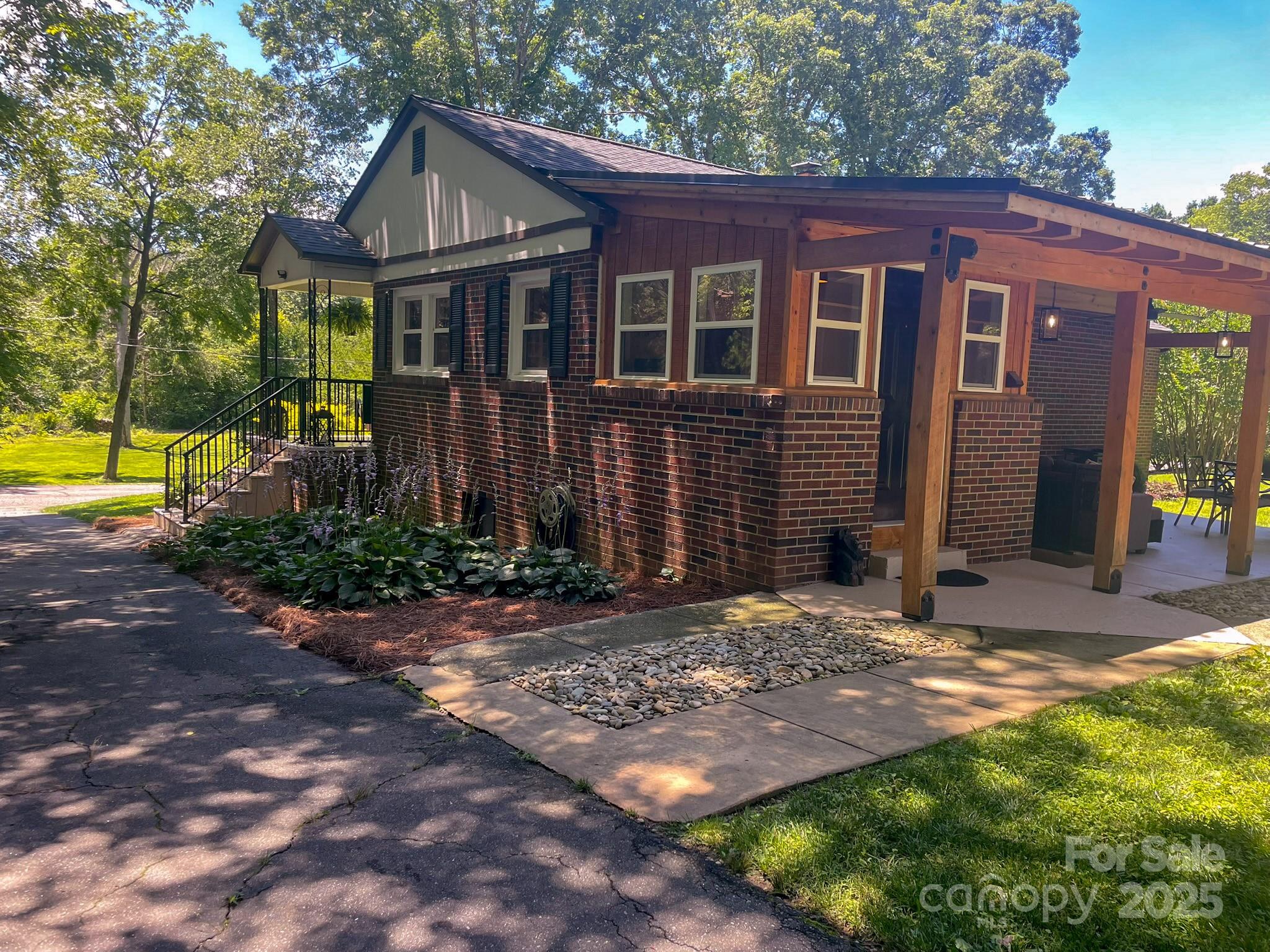 107 Byrd Street Morganton, NC 28655 - Photo 29 of 46 a view of a brick house with many windows plants and large tree