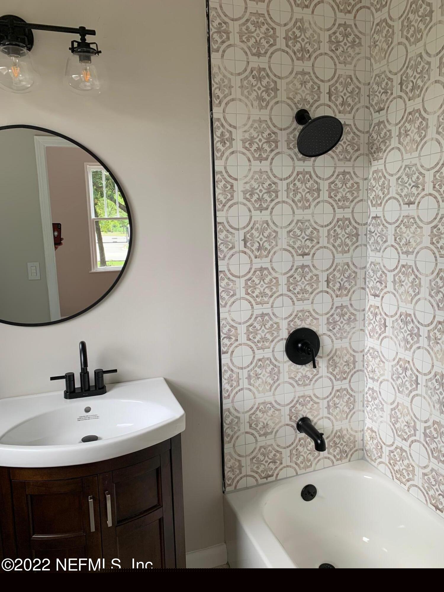 1821 Anniston Road Jacksonville, FL 32246 - Photo 7 of 11 a bathroom with a sink and a mirror