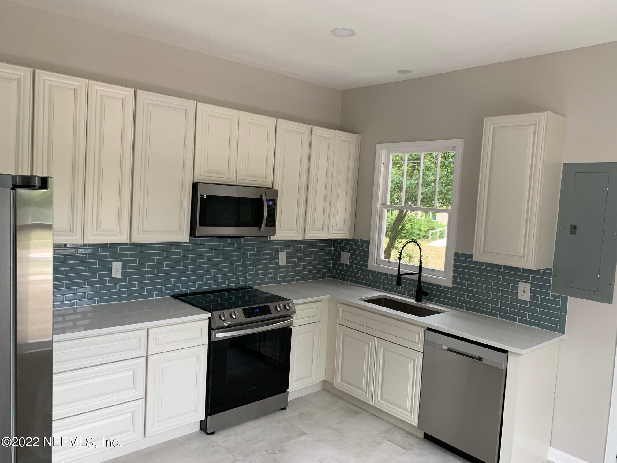 1821 Anniston Road Jacksonville, FL 32246 - Photo 10 of 11 a kitchen with granite countertop white cabinets and black appliances