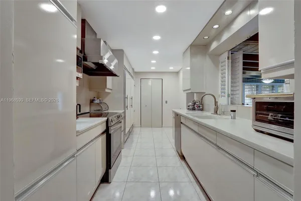 a large kitchen with stainless steel appliances kitchen island granite countertop a stove and a sink with granite countertops