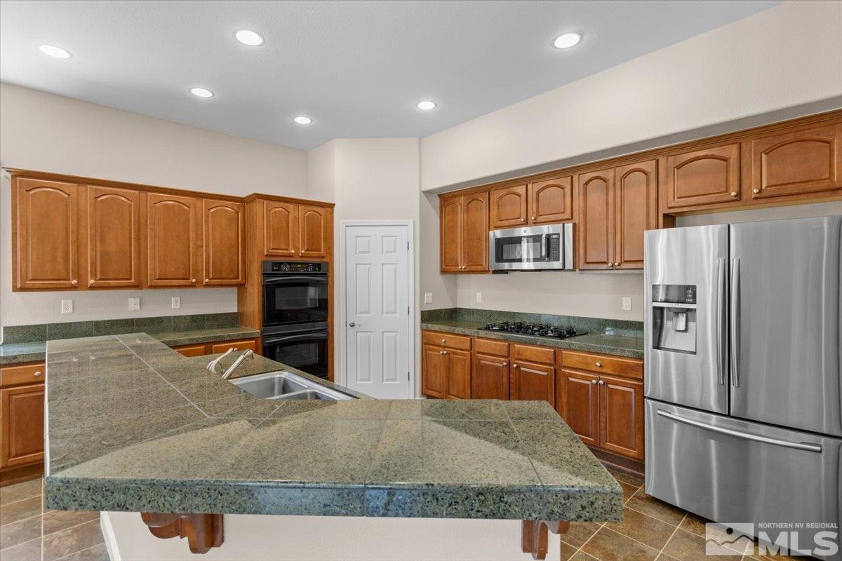 10560 Dillingham Drive Reno, NV 89521 - Photo 14 of 40 a kitchen with stainless steel appliances granite countertop a refrigerator a stove and a sink