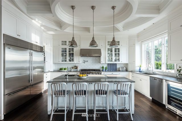 a kitchen with stainless steel appliances granite countertop a sink a stove a refrigerator and island