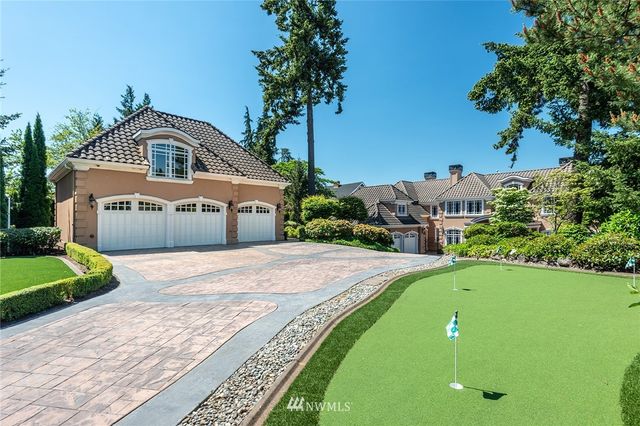 a front view of a house with a yard and trees