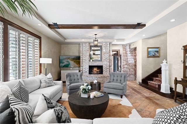 a living room with furniture a fireplace and a large window