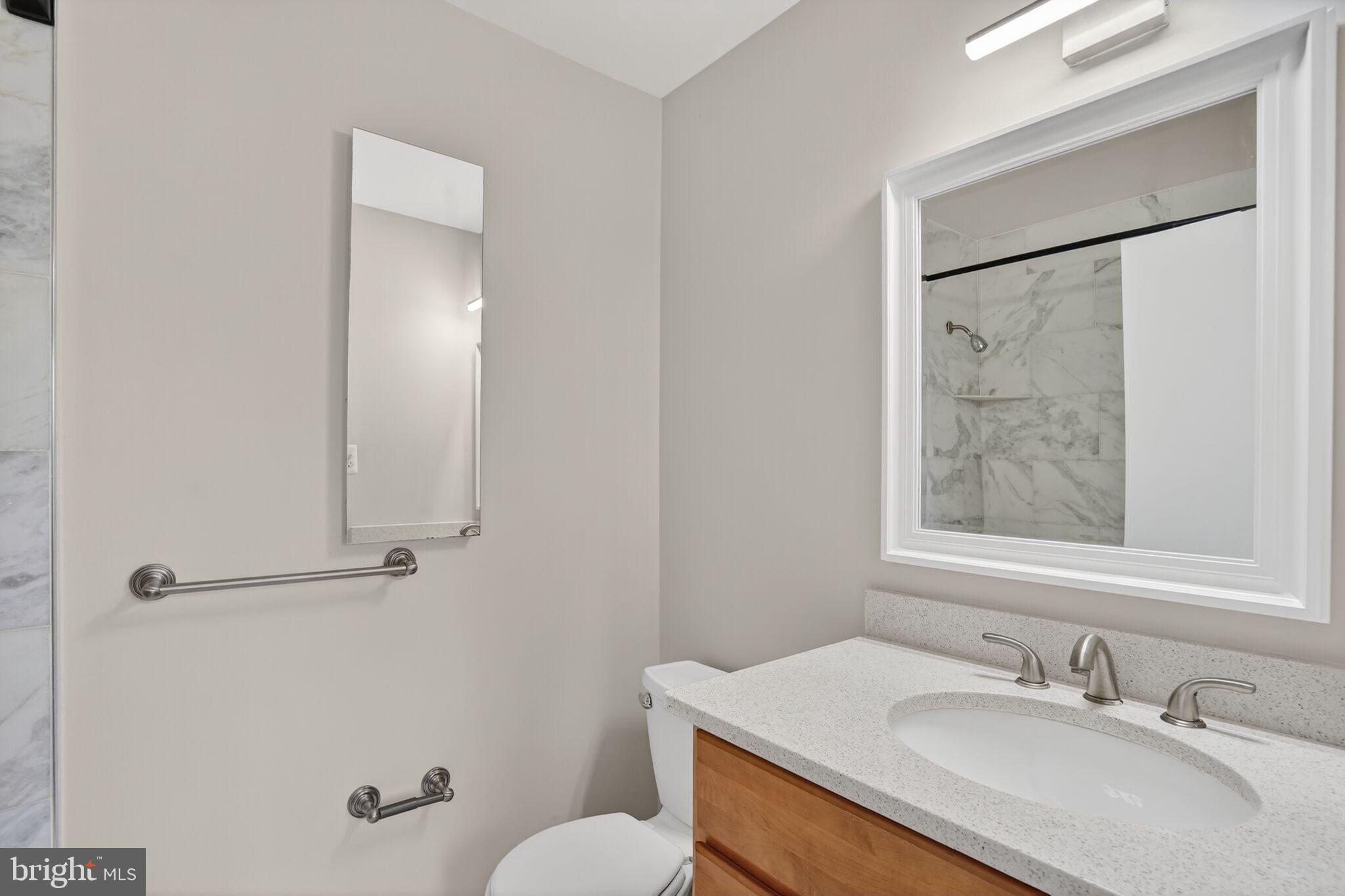 3052 Sugar Lane Vienna, VA 22181 - Photo 13 of 28 a bathroom with a granite countertop sink toilet and shower