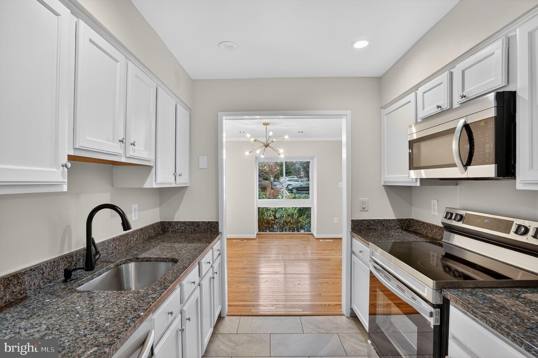 3052 Sugar Lane Vienna, VA 22181 - Photo 7 of 28 a kitchen with granite countertop a stove sink and microwave