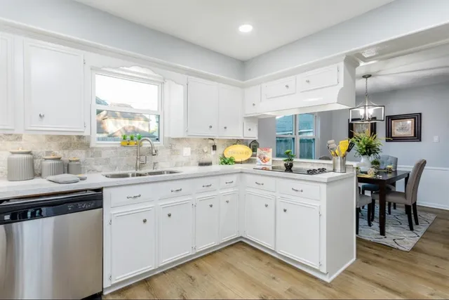a kitchen with granite countertop white cabinets and white appliances