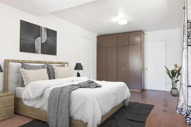 a bedroom with a large bed and potted plant