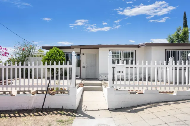 a view of a house with wooden fence