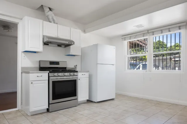 a kitchen with cabinets a stainless steel appliances and a window