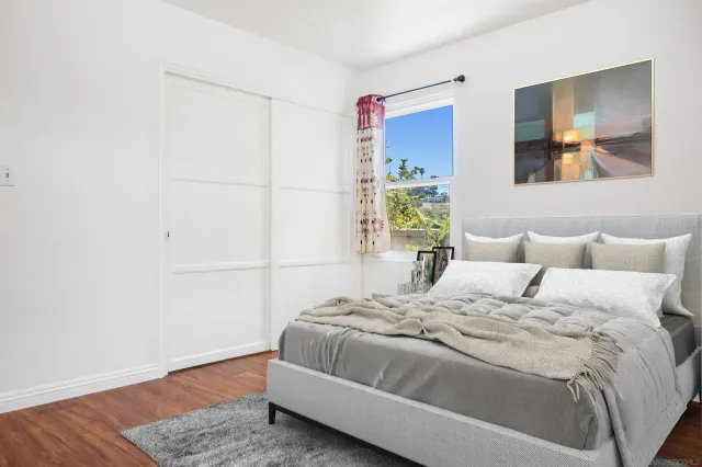 a bedroom with a bed and painting on the wall