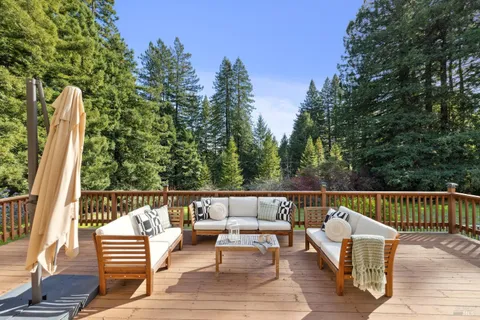a view of a deck with couches wooden floor and fence