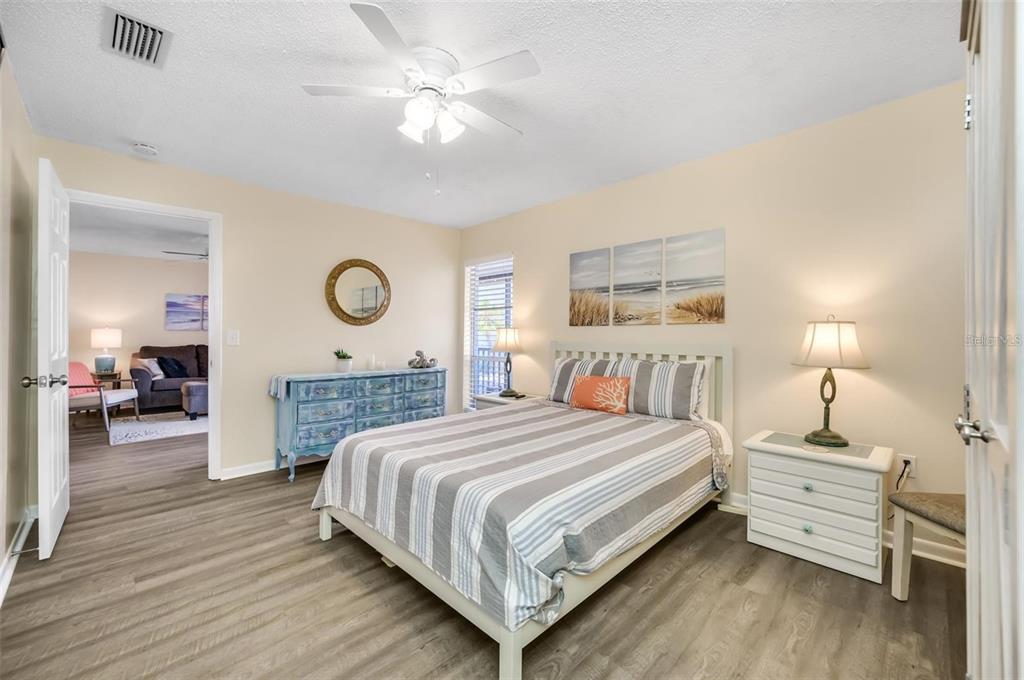 260 Medallion Boulevard, Unit F Madeira Beach, FL 33708 - Photo 13 of 29 a bedroom with a bed and a chandelier