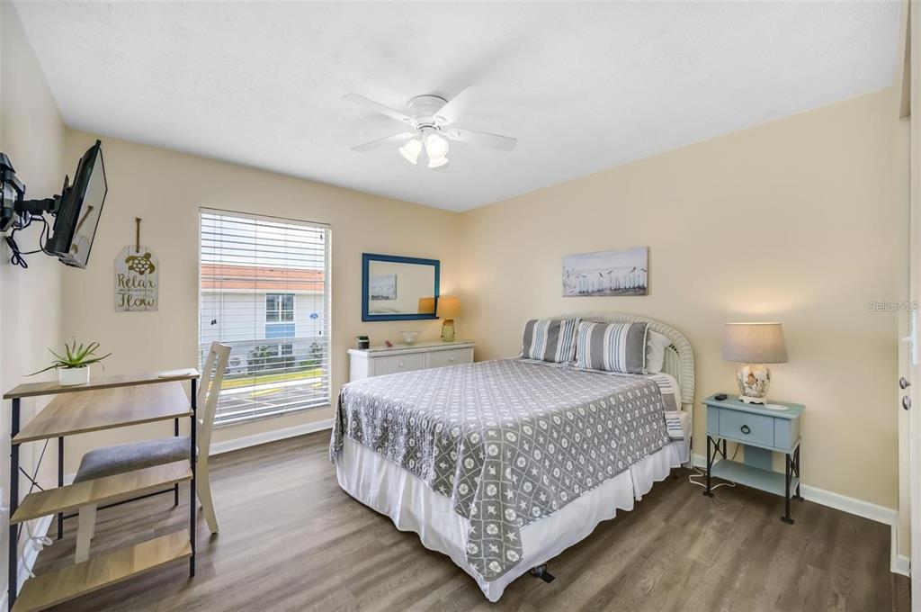 260 Medallion Boulevard, Unit F Madeira Beach, FL 33708 - Photo 15 of 29 a bedroom with a large bed and a chandelier