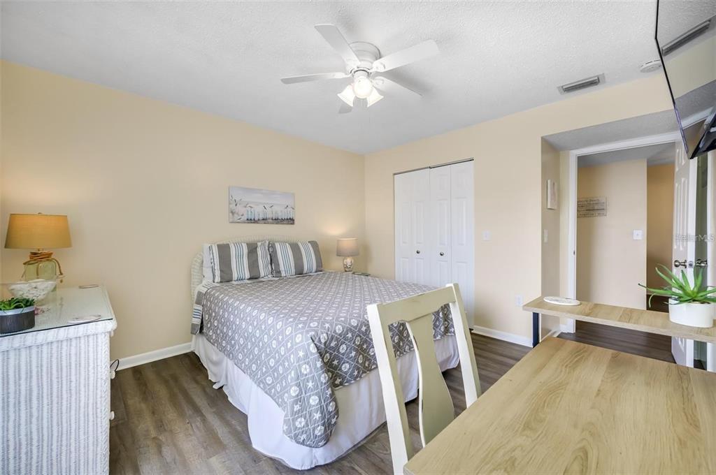 260 Medallion Boulevard, Unit F Madeira Beach, FL 33708 - Photo 17 of 29 a bedroom with a bed and a chandelier