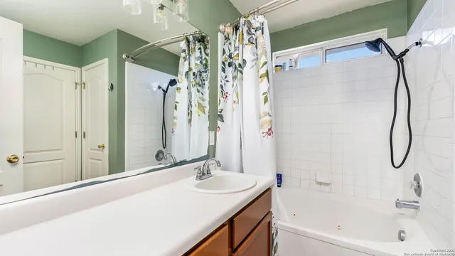 a bathroom with a granite countertop sink a mirror and a shower