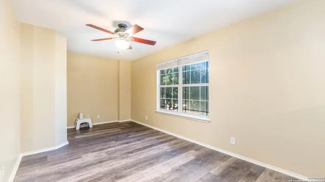 a view of a livingroom with wooden floor and a ceiling fan