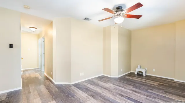 a view of a room with wooden floor and a ceiling fan