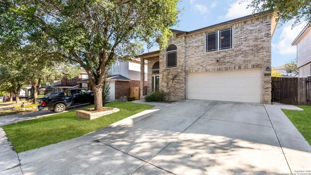 a view of a white house with a yard and large trees