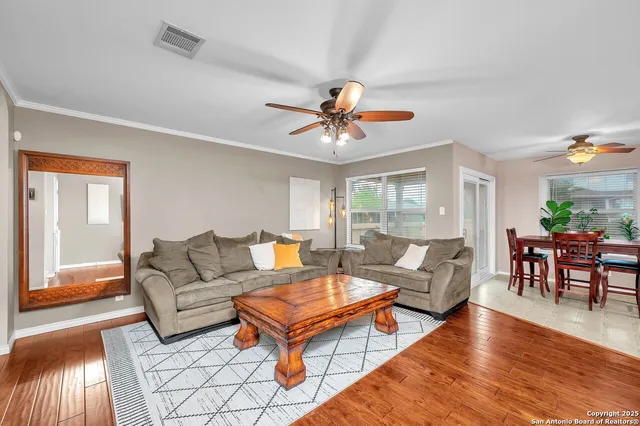 a living room with furniture a table and wooden floor