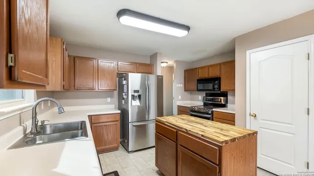 a kitchen with stainless steel appliances a refrigerator a sink a stove a microwave and cabinets