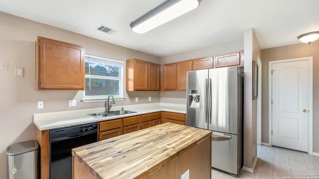 a kitchen that has a sink a refrigerator and a sink
