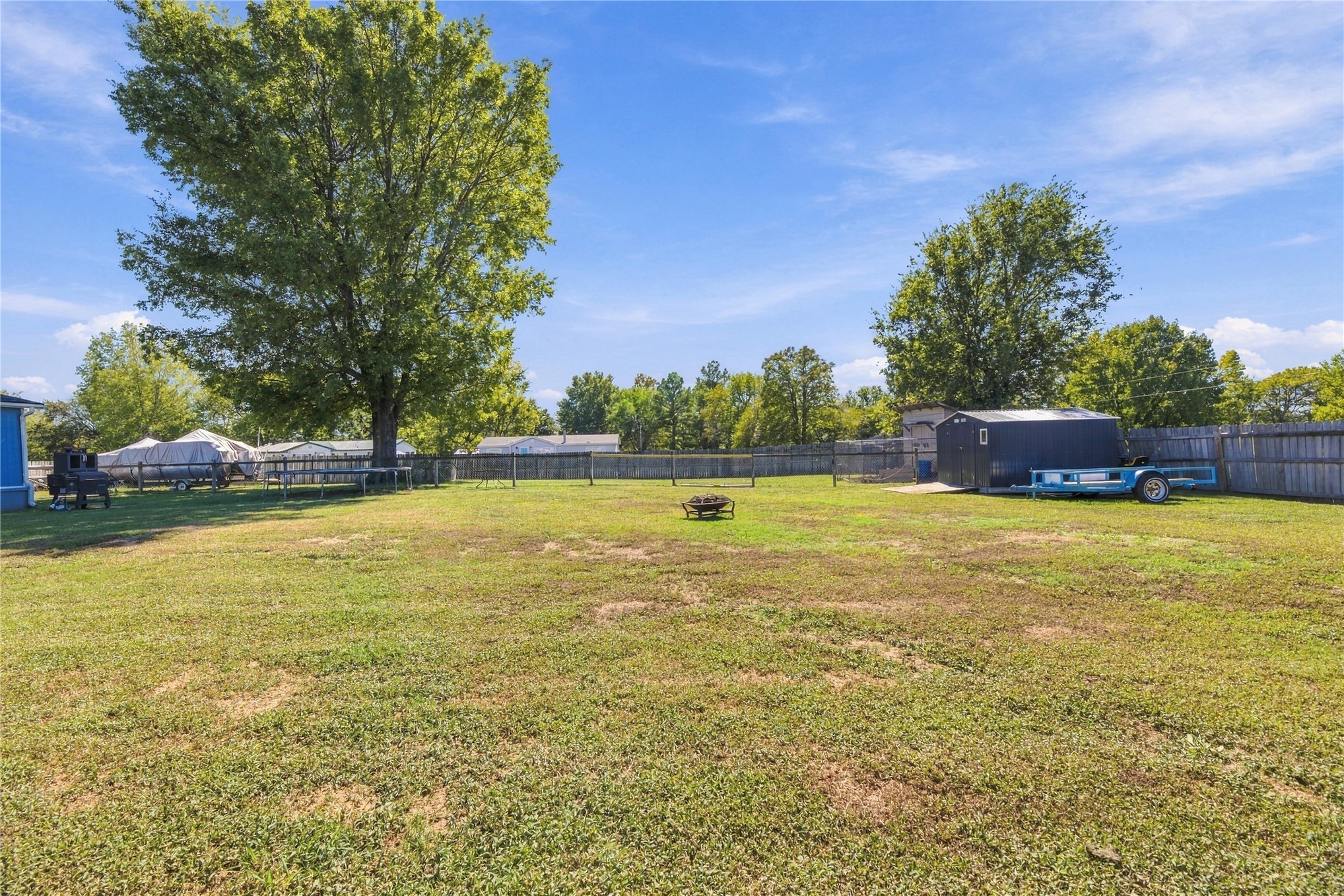 15 Sun Prairie Road Pryor, OK 74361 - Photo 23 of 34 Spacious backyard with a wood privacy fence, mature tree, and a storage shed
