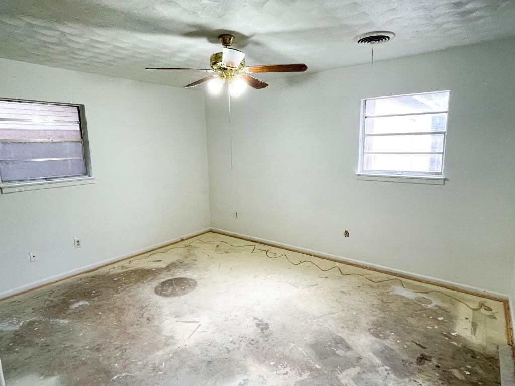 5503 36th Street Lubbock, TX 79407 - Photo 6 of 15 an empty room with a window and a fan