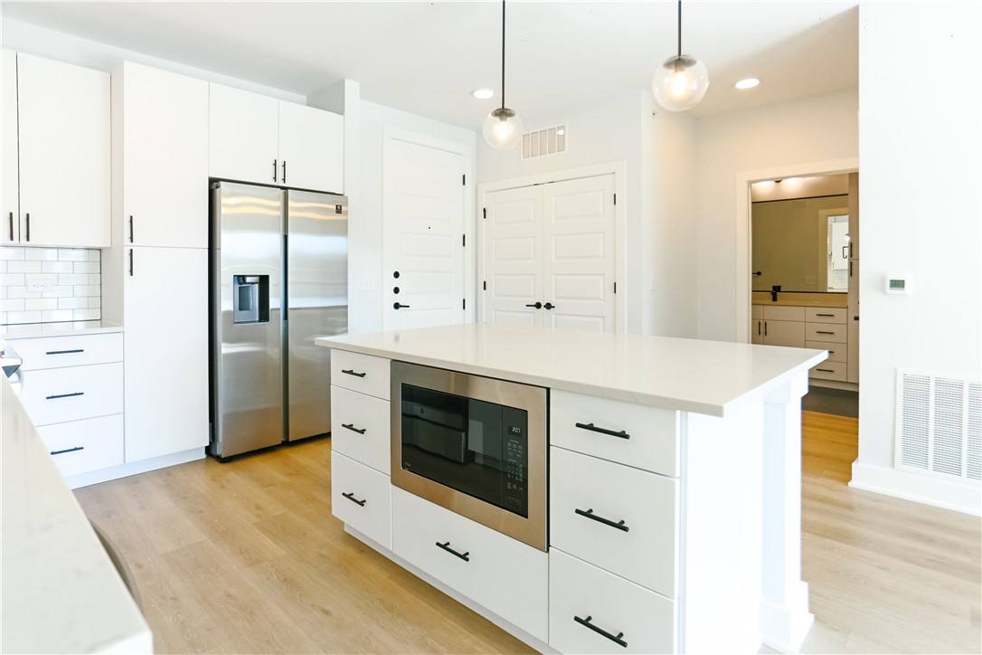 a kitchen with stainless steel appliances a white cabinet and a refrigerator